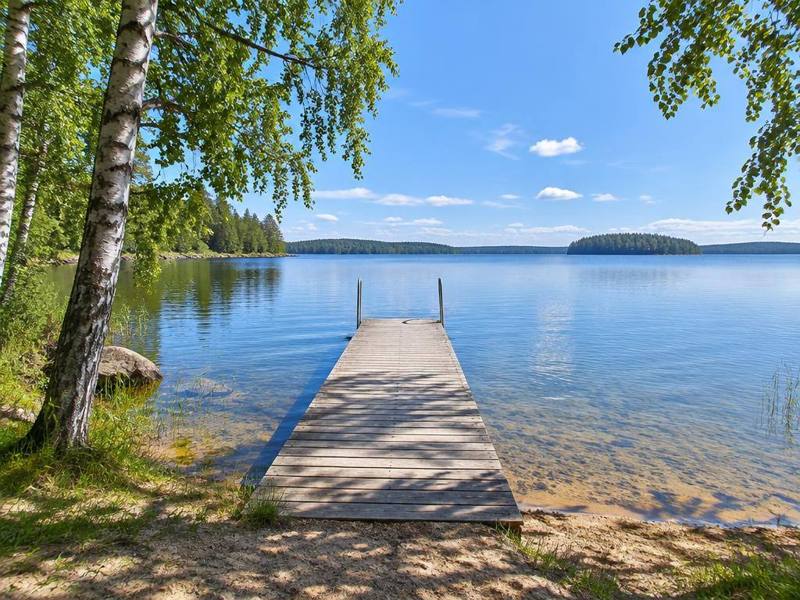 Badplats med brygga i en stilla sjö en sommardag